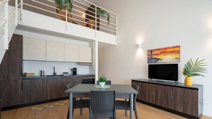 Una cucina moderna con zona pranzo, TV e balcone con piante.