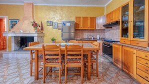 A kitchen with a central island, wooden cabinets, a tiled backsplash, and a built-in oven.