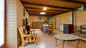 A wooden interior with a dining area, kitchen, and seating.