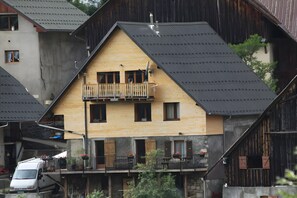 Een meerlaags gebouw met een houten gevel, balkons en een schuin dak.