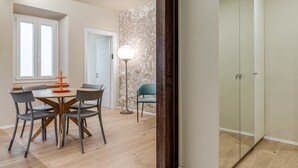 A modern room with a dining table, chairs, a floor lamp, and a mirror.