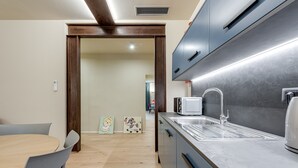 Une cuisine moderne équipée d’un four à micro-ondes encastré, d’un évier et d’un coin repas avec une table et des chaises.