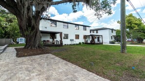 A two-story white building with a covered porch and a large tree in front. - Remodeled unit steps from San Marco cafes and shops and near Riverwalk (Jacksonville)