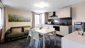 En kompakt bolig med spiseplads, tekøkken og sofa.