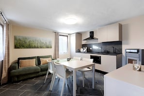 Un espacio habitable pequeño con comedor, kitchenette y sofá.