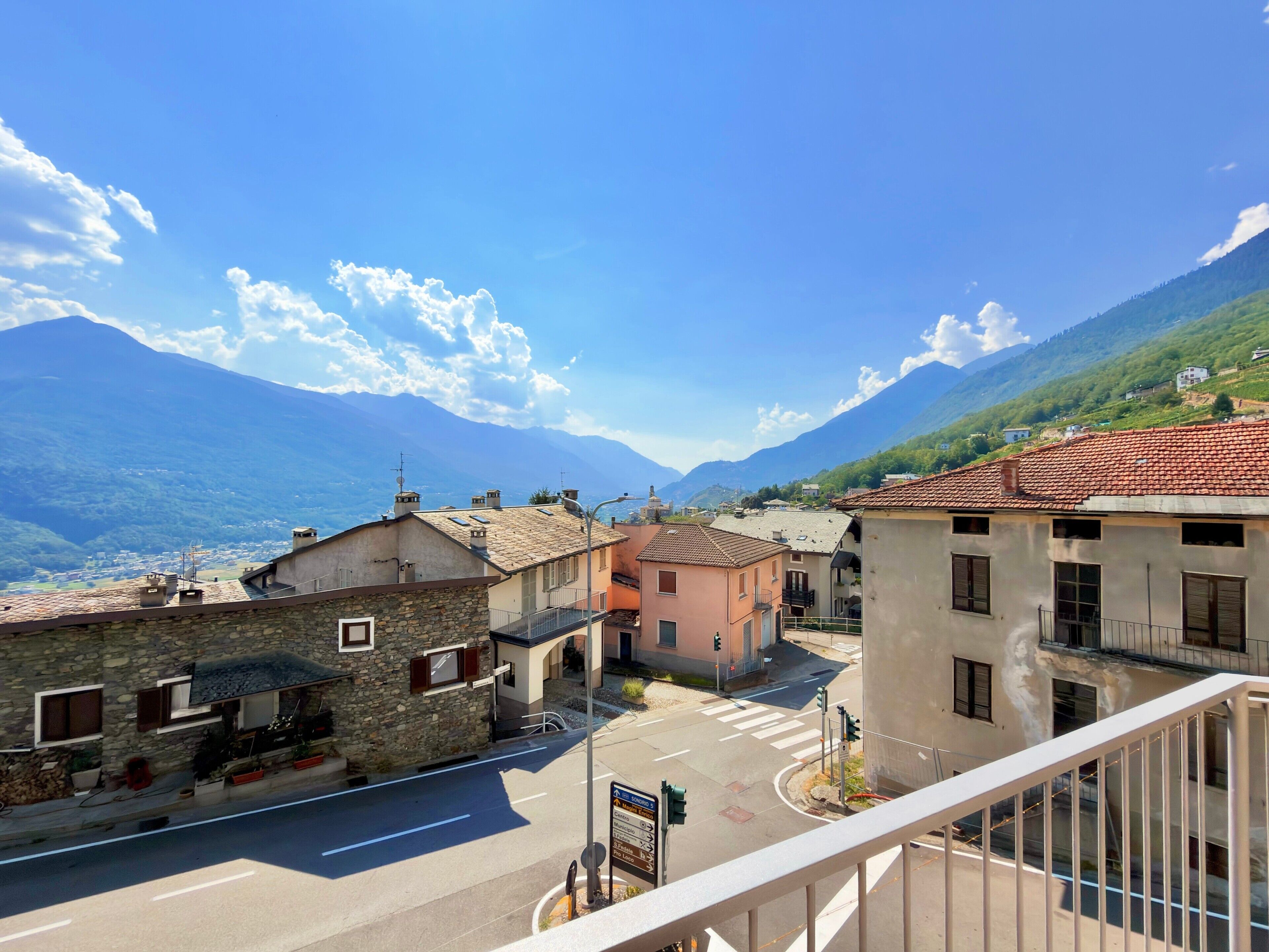 Une vue de rue avec des bâtiments, un passage piéton et une montagne en arrière-plan.
