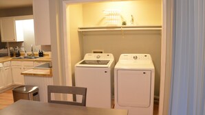A compact kitchen with a sink, cabinets, and a table.