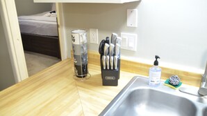 A kitchen with a sink, a coffee maker, a knife block, and a bottle of hand soap.