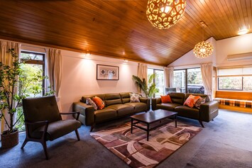 Spacious lounge with fireplace, 65" TV, and plenty of comfy seating for relaxing together.
