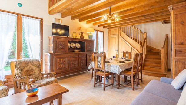 A wooden interior with a dining area, a sofa, and a staircase. - Les 2 plages by Interhome (Vaux Sur Mer)