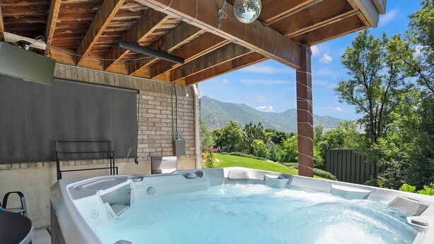 Ein Whirlpool unter einer Holzpergola mit Blick auf die Berge.