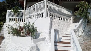 Un escalier blanc, doté d’une balustrade, mène à une zone abritée.