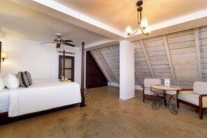 A hotel room with a bed, a ceiling fan, a table with chairs, and a view of the outside. - Hotel Boutique Patio Corao By GEH Suites (Cartagena)