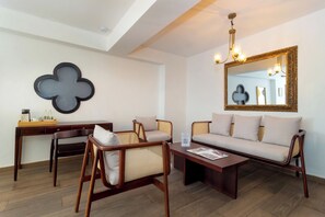 A modern living room with a sofa, two armchairs, a coffee table, and a decorative wall piece. - Hotel Boutique Patio Corao By GEH Suites (Cartagena)