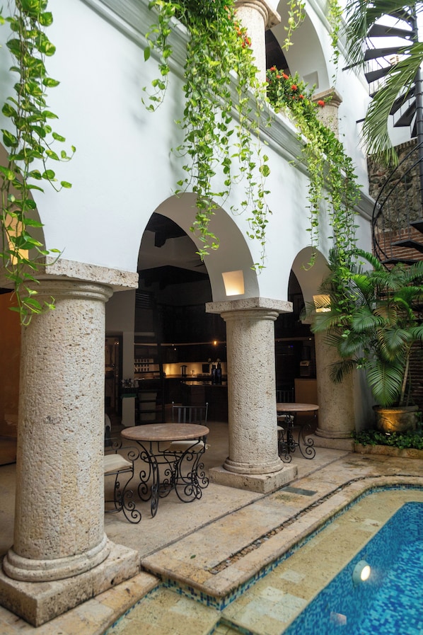 A courtyard with a pool, stone columns, and arches. - Hotel Boutique Patio Corao By GEH Suites (Cartagena)