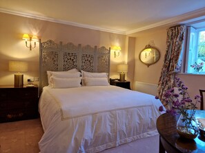 A neatly made bed with white linens, two bedside lamps, a decorative headboard, a mirror, and a window with floral curtains. - Historic Nile Lodge House, 6 Nile Lodge, Galway City , 5 bedrooms, sleeps 10 (Galway)