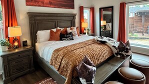 A bedroom with a large bed, a headboard, a nightstand, a bedside table, a mirror, a window with curtains, and a view of the outside. - New House/with Pool/Hot Tub/Putting Green/Close to Universal Studios/Theme Rooms (Frisco)