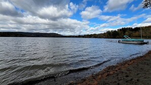 A lake with a dock and a boat. - Grandparent’s Cottage 250 steps to the lake (Stockbridge)