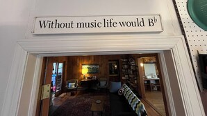 A doorway with a sign that reads "Without music life would B". - Grandparent’s Cottage 250 steps to the lake (Stockbridge)