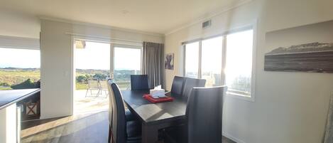 A dining area with a table, chairs, and a view of the outdoors.