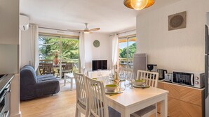 Eine moderne Küche mit Essbereich, großen Fenstern und einem Deckenventilator.