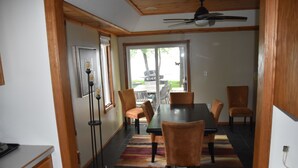Un comedor con una mesa y sillas, un ventilador de techo y vistas al exterior.