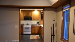 Una cocina con armarios de madera, estufa y microondas.