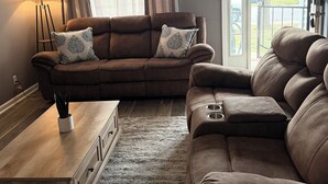 A living room with a brown leather sofa, a wooden coffee table, and a floor lamp.