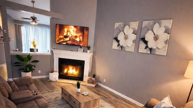 A living room with a fireplace, sofas, and artwork on the wall.