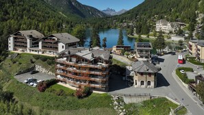 A mountain resort with multiple buildings, a parking area, and a lake. - Les Combins 30 by Interhome (Champex)