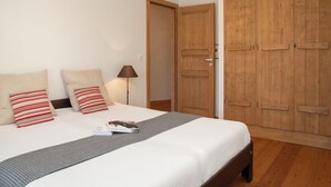 A bedroom with a bed, pillows, a bedside lamp, and wooden wardrobes. - Les Combins 30 by Interhome (Champex)