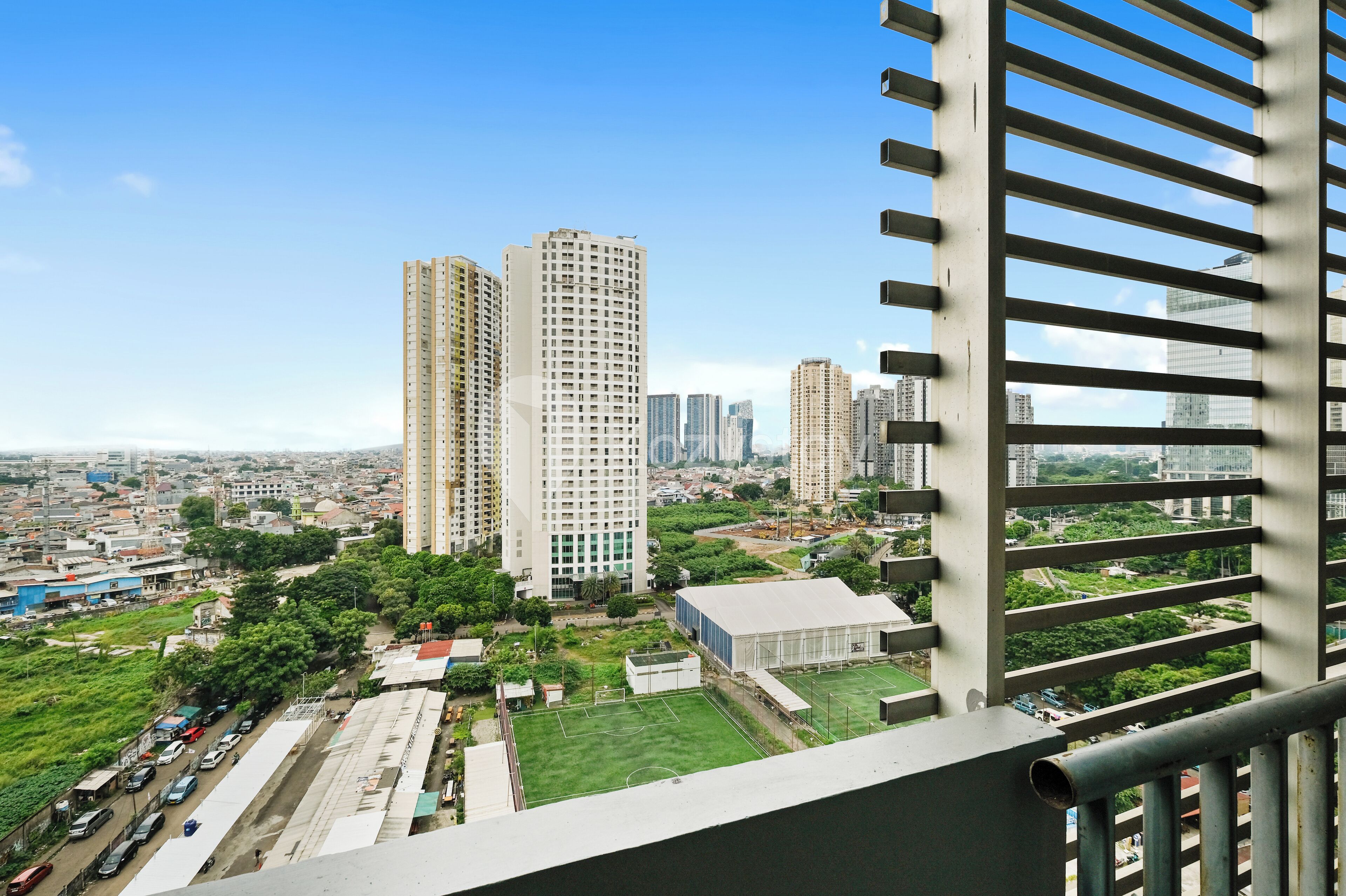 A high-rise building with multiple floors, surrounded by other high-rise buildings and greenery.