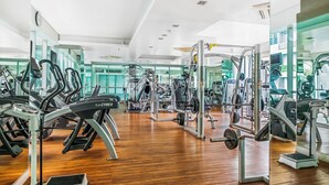 Une salle de sport équipée de machines de cardio, de matériel de musculation et de miroirs aux murs.