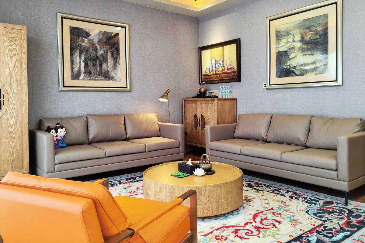 Ein modernes Wohnzimmer mit zwei Sofas, einem Couchtisch und Kunstwerken an den Wänden.