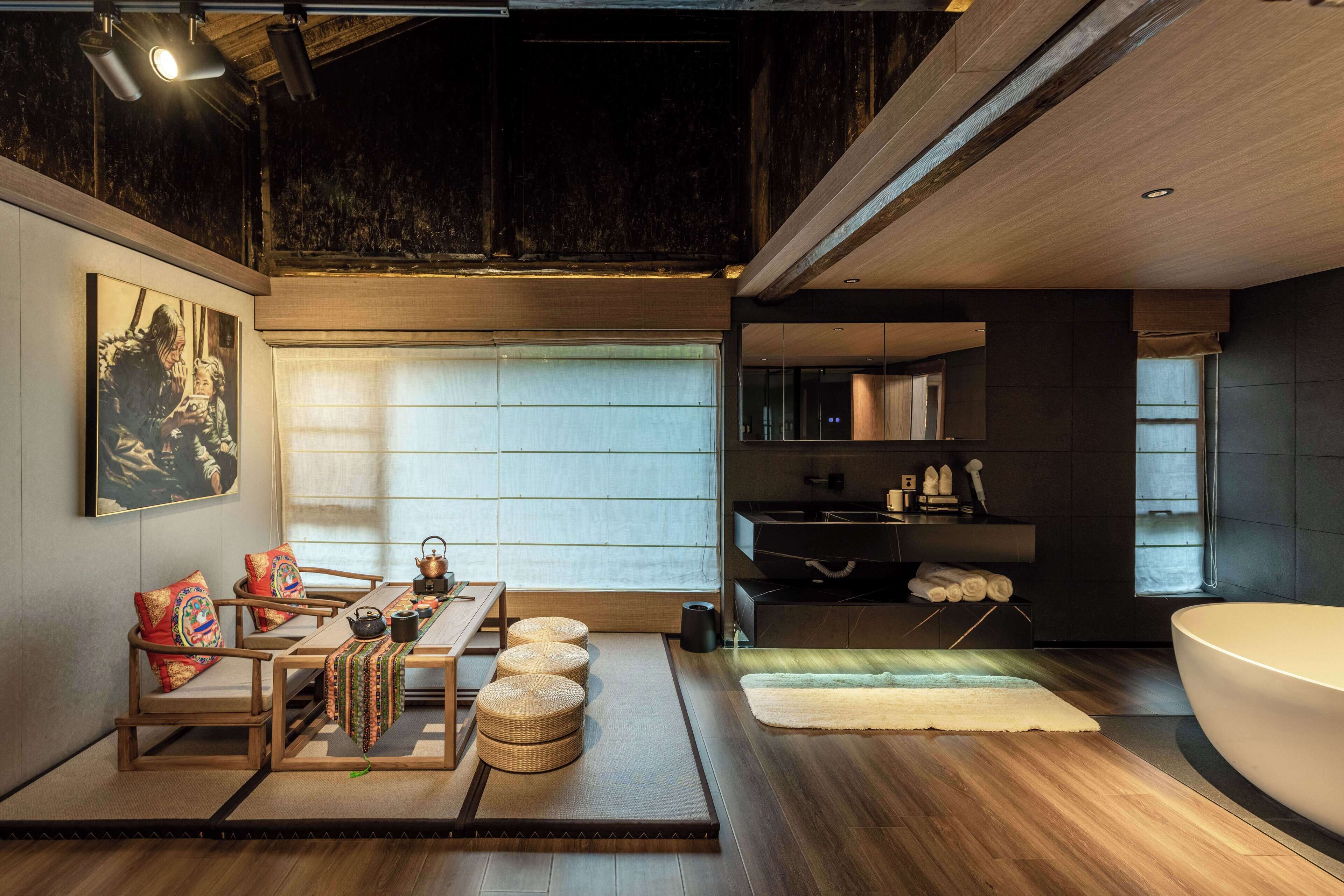 A modern interior with a tatami mat dining area, a large bathtub, and a minimalist bathroom.