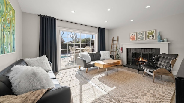 A living room with a sofa, coffee table, fireplace, and large windows.