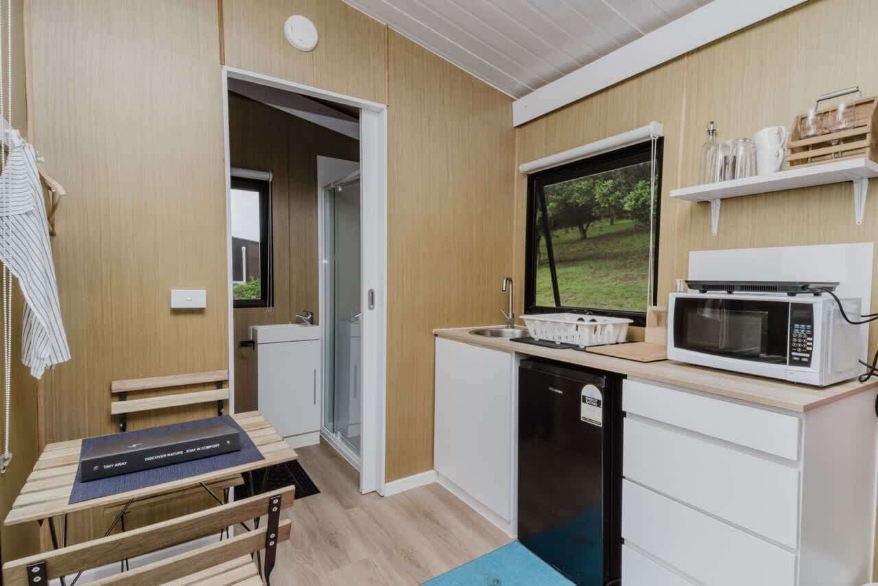 A compact kitchen with a microwave, sink, and a view of the outdoors.