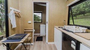 A compact kitchen with a window, a sink, and a small dining area.