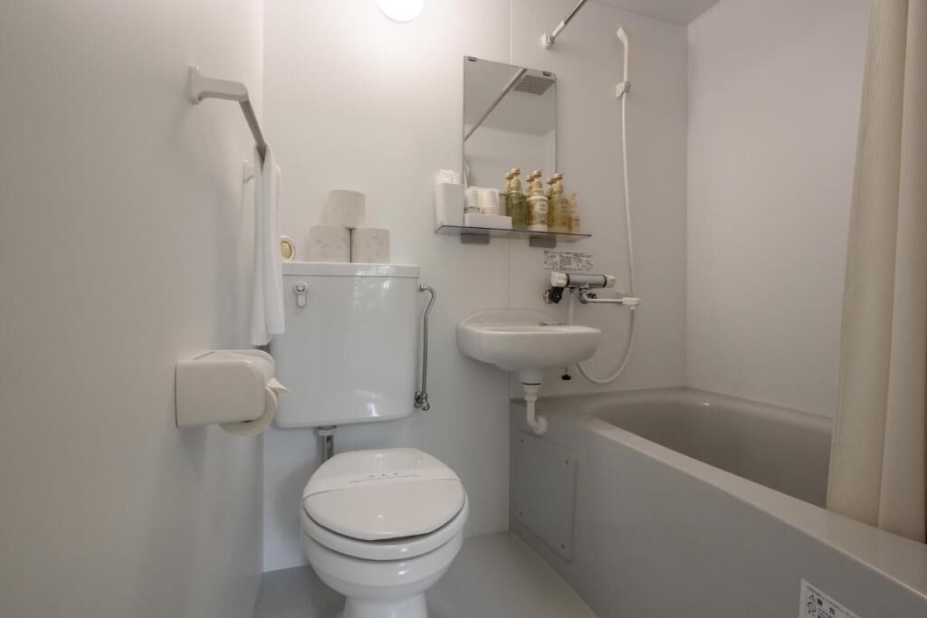A modern bathroom with a toilet, sink, and bathtub.