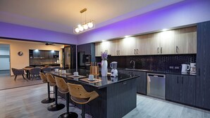 A modern kitchen with a central island, bar stools, and contemporary cabinetry.
