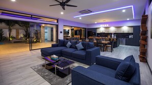 A modern living room with a sectional sofa, a coffee table, and a ceiling fan.