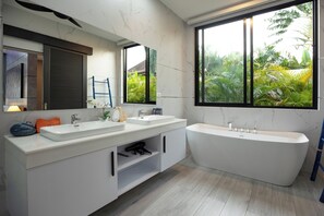 A modern bathroom with two sinks, a bathtub, and large windows with a view of greenery. - Stunning 4 bedrooms pool villa at Rawai (Tambon Rawai)