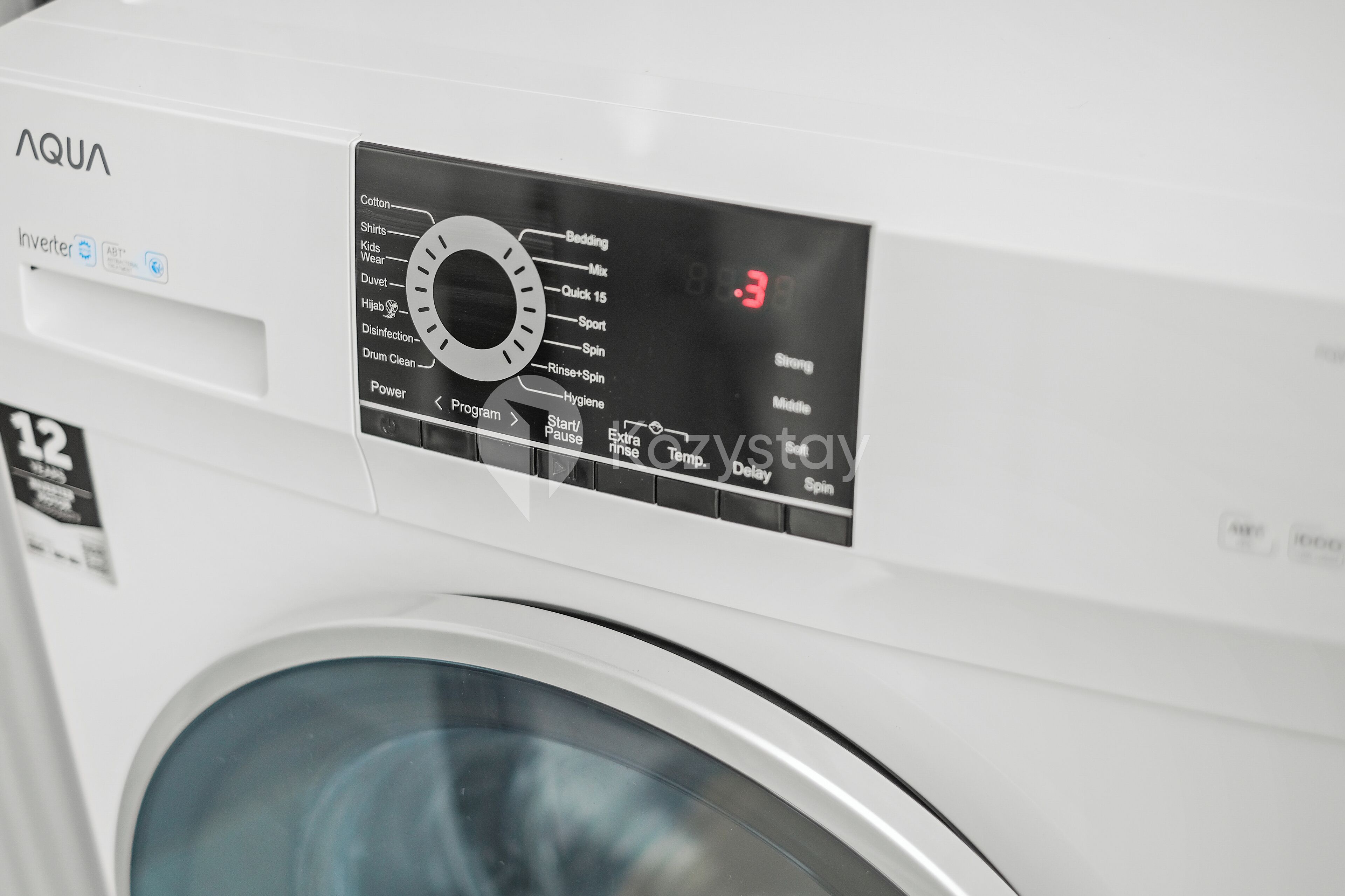 A front view of a white washing machine with a control panel displaying various settings and a digital display showing the time as 19:3.