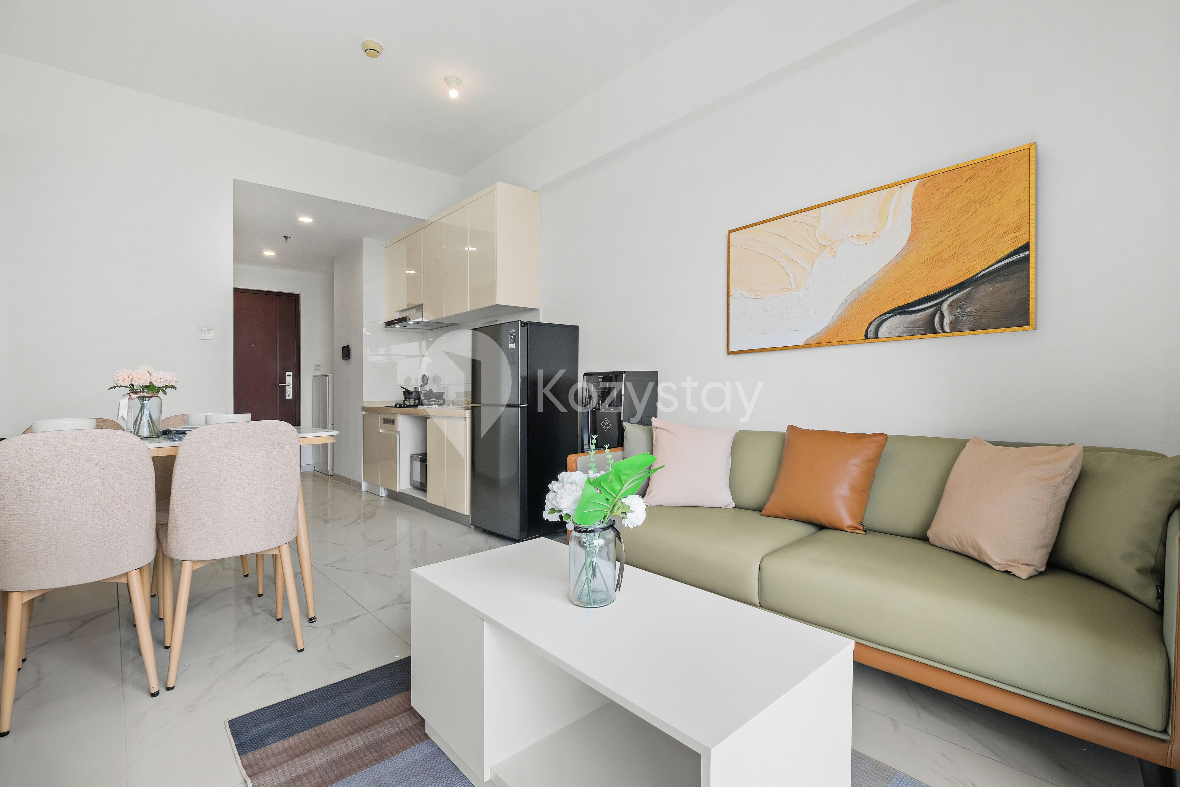 A modern living room with a sofa, coffee table, and dining area.