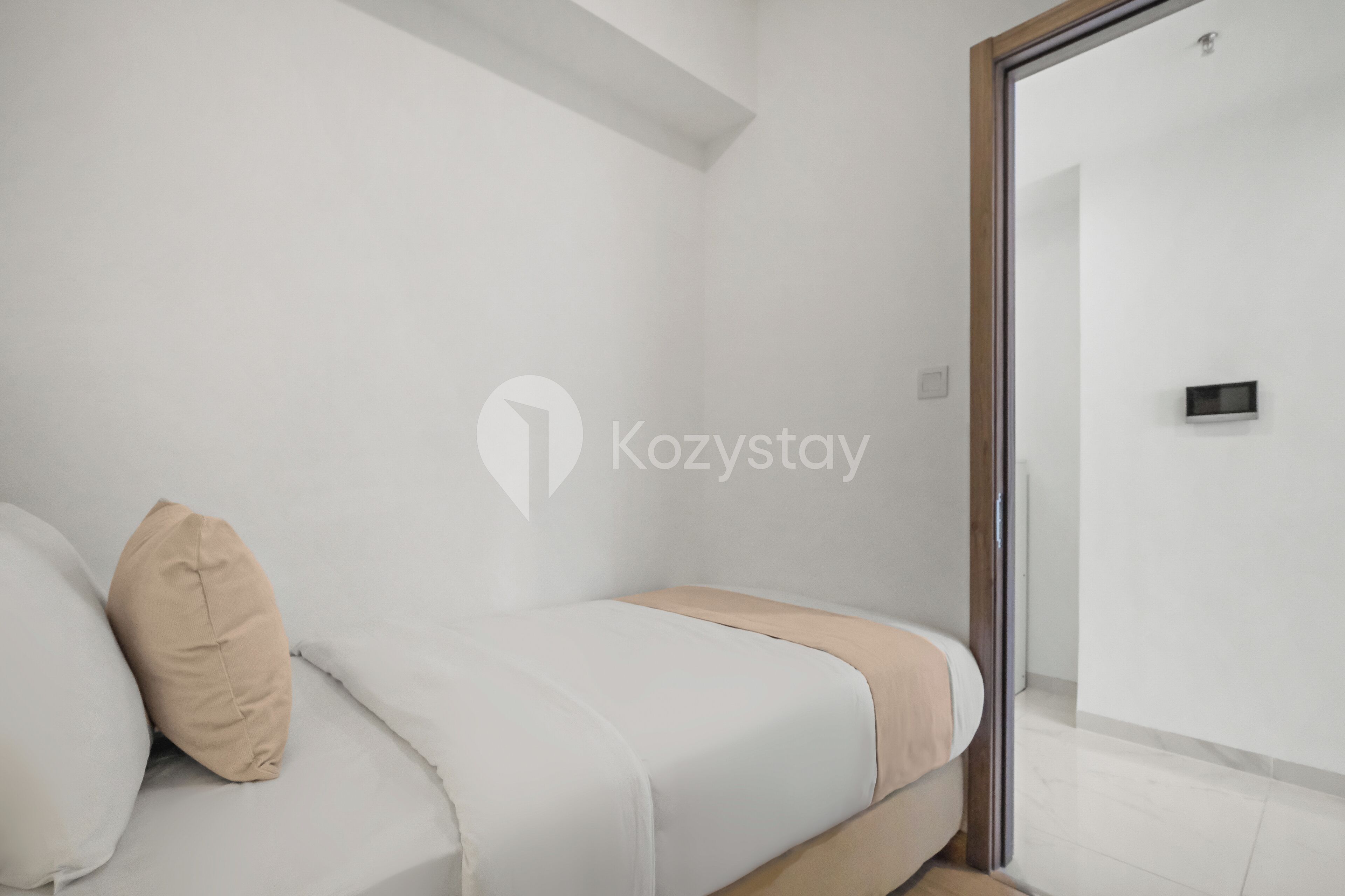 A minimalist bedroom with a bed, a beige pillow, and a white mattress.