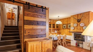 A wooden interior with a staircase, a dining area, and a fireplace. - Boiserie by Interhome (Campitello)