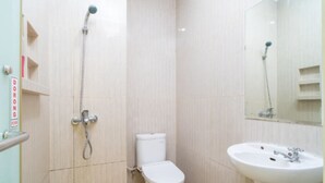 A bathroom with a toilet, a sink, and a shower. - Tebet Utara Residence (Jakarta)