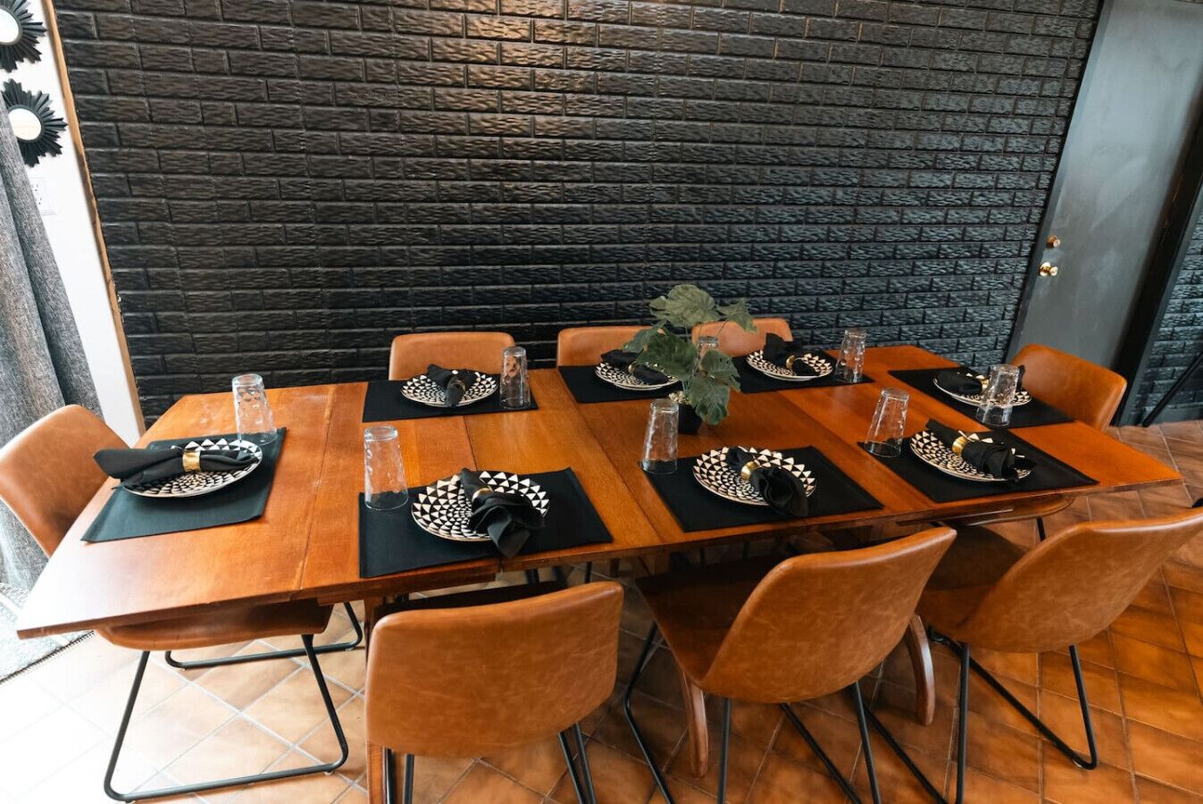 Comedor con una larga mesa de madera dispuesta para seis personas, rodeada de seis sillas.