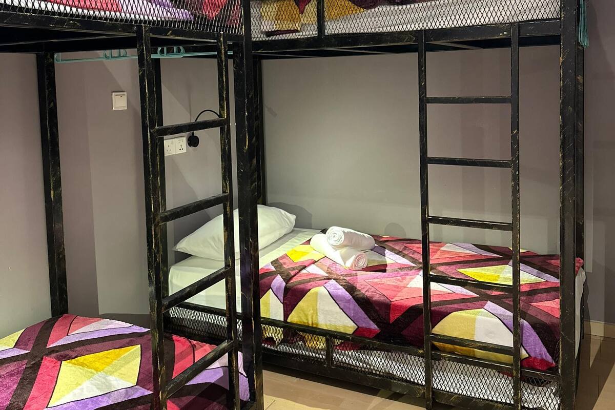 A bunk bed room with a power outlet and an air conditioning unit on the wall.