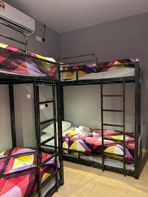 A bunk bed room with a power outlet and an air conditioning unit on the wall. - BRIGHTON INN & CAMPING RESORT (Miri)